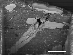 Een beeld van een elektronenmicroscoop van een inslagkrater van een micrometeoriet in een deeltje van asteroïde Bennu-materiaal (Afbeeldingsbron: NASA, en Zia Rahman)
