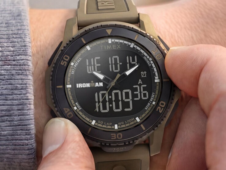 Een zandkleurig Timex Ironman Adrenaline ana-digi-horloge, afgebeeld om een pols, met een zwarte lunette en een zichtbaar digitaal display.