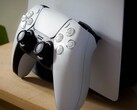 Een afbeelding van een PlayStation 5 DualSense-controller die tegen een PS5-console leunt