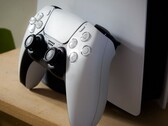 Een afbeelding van een PlayStation 5 DualSense-controller die tegen een PS5-console leunt