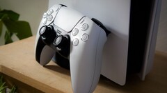 Een afbeelding van een PlayStation 5 DualSense-controller die tegen een PS5-console leunt