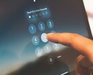 Een vinger toetst een pincode in op een cijfertoetsenbord op het scherm
