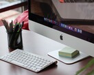 Een iMac op een bureau, met het macOS-dock zichtbaar op het scherm en een Apple-toetsenbord ervoor