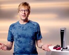  Mark Cerny tijdens een PlayStation-evenement, zittend naast een PS5-console en DualSense-controllers. (Afbeelding Bron: Sony Interactive Entertainment)