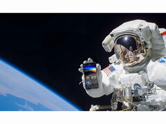 Een promotionele afbeelding voor de gratis NASA+ service met een astronaut die een smartphone vasthoudt met de NASA+ app geopend in de ruimte. (Afbeelding Bron: NASA)