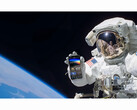 Een promotionele afbeelding voor de gratis NASA+ service met een astronaut die een smartphone vasthoudt met de NASA+ app geopend in de ruimte. (Afbeelding Bron: NASA)