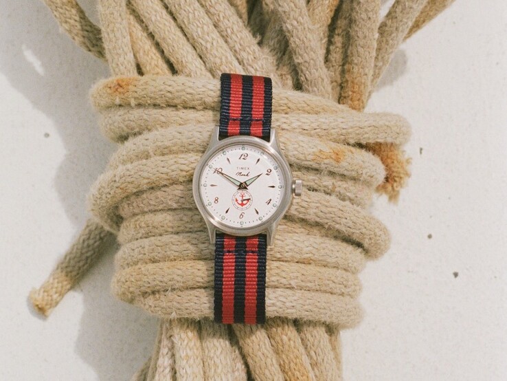 Noah x Timex MK1 Anchor-horloge met een zilverkleurige kast van 36 mm, een witte wijzerplaat, een ankerafbeelding en een gestreepte stoffen band in marineblauw en rood.
