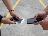 Twee mensen die twee smartphones naast elkaar vasthouden tijdens een overdracht