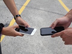 Twee mensen die twee smartphones naast elkaar vasthouden tijdens een overdracht