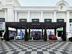 Beursstand van Volvo op Realestate.com.kh Expo 2022, met meerdere Volvo's, waaronder SUV's, met reclamebanners en branding voor een groot wit gebouw met zuilen. (Afbeelding bron: I'm Zion via Pexels)