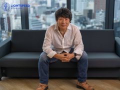 Een foto van Hideaki Itsuno zittend op een bank bij Tencent LightSpeed Studios (beeldbron: LightSpeed Studios)