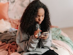 Tiener die een smartphone gebruikt op een bed, symbolische afbeelding voor ChatGPT for Teens en ouderlijk toezicht