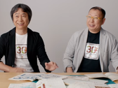 Een screengrab van Shigru Miyamoto en Tezuka Takashi in t-shirts ter ere van de 30e verjaardag van Super Mario Bros