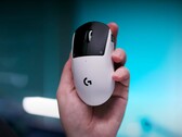 Logitech G Pro X2 Superstrike gaming muis in een hand op een blauwe achtergrond