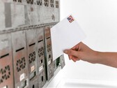 Een hand die een envelop in een rij brievenbussen steekt