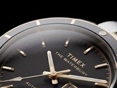 Close-up van de Timex Waterbury Heritage Automatic met zwarte wijzerplaat, waarop de gefacetteerde, lichtgevende wijzers, de uurmarkeringen, de dag- en datumweergave en de zwarte lunette te zien zijn.