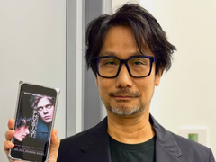 Hideo Kojima toont een poster van Physint op zijn telefoon