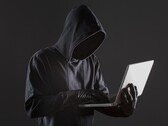 Een gehulde hacker bedient een laptop tegen een donkere achtergrond.
