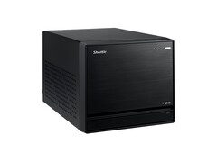 De afbeelding toont een vooraanzicht van de Shuttle XPC Mini PC, die eruitziet als een zwarte kubus met een minimaal ontwerp. 