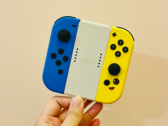 Stockafbeelding. Een hand die Joy-Cons vasthoudt (Afbeelding bron: Gwen King op Unsplash)
