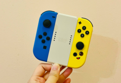 Stockafbeelding. Een hand die Joy-Cons vasthoudt (Afbeelding bron: Gwen King op Unsplash)