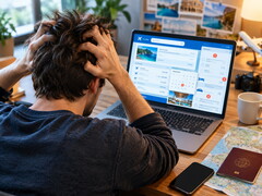 Persoon die achter een laptop zit en problemen heeft met een reisboeking