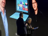 Huang neemt de Surface RT in ontvangst: Daarachter staat een foto van de presentatie uit 2012.