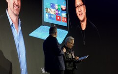 Huang neemt de Surface RT in ontvangst: Daarachter staat een foto van de presentatie uit 2012.