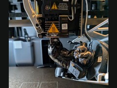 Een klodder filament op de spuitmond van een Bambu Lab 3D-printer