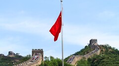 De Chinese vlag met de Chinese Muur op de achtergrond