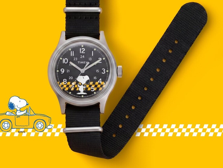 Peanuts x Timex MK1-horloge met een zwarte wijzerplaat waarop Snoopy en een geel-zwart geruit patroon zijn afgebeeld, afgebeeld met de zwarte stoffen band tegen een gele achtergrond.