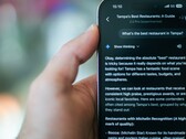 Iemand die hun telefoon gebruikt om een restaurant te vinden met Gemini