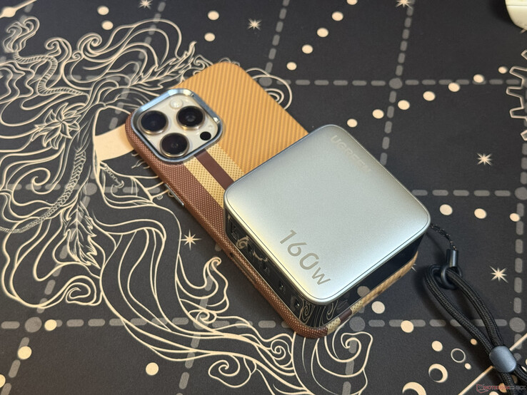 De Ugreen Nexode Pro 160W met vijf poorten bovenop de iPhone 16 Pro Max
