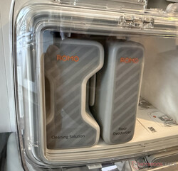 De twee wasmiddelcontainers achter plexiglas