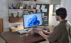 Minisforum heeft zijn AI X1 Pro mini-pc, afgebeeld naast een monitor en toetsenbord op een bureau, vernieuwd met nieuwe AMD-hardware (bron: Minisforum)