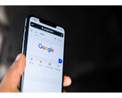 Een foto van een hand die een smartphone vasthoudt met de startpagina van Google Search geopend op het scherm. (Afbeelding bron: Solen Feyissa op Flickr)