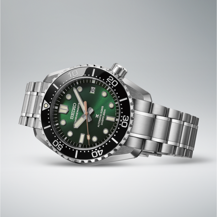 HBF003J1 rustend op zijn zijkant, met nadruk op de roestvrijstalen kast van 42.6mm, gefacetteerde kastaanzetten, zwarte lunette, groene wijzerplaat en geïntegreerde band.