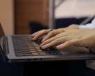 Handen die op het toetsenbord van een donkere laptop typen