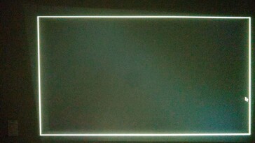 Wanneer de Yaber T1 Pro projector niet recht op een muur gericht is, past het het beeld aan om waterpas te lijken door de projectie bij te snijden. In het ongebruikte gebied (linksboven) blijft een zeer zwakke lichtafloop zichtbaar. (f/1.6 3/10 sec ISO 3200) (Afbeeldingsbron: Notebookcheck)