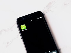 Een smartphone op een witte tafel waarop de WhatsApp-app te zien is
