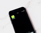 Een smartphone op een witte tafel waarop de WhatsApp-app te zien is