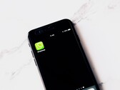 Een smartphone op een witte tafel waarop de WhatsApp-app te zien is