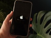Een hand houdt een iPhone vast; op het scherm zijn het Apple-logo en een voortgangsbalk te zien.