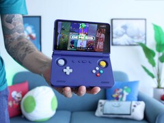 Russ van Retro Game Corps houdt de Retroid Pocket Flip 2 handheld spelconsole in paars vast, met op het scherm een Sega Genesis emulatorinterface. (Afbeelding bron: Retro Game Corps op YouTube)