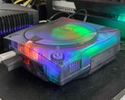 Een foto van een gemodificeerde SEGA Dreamcast met een doorschijnende behuizing in werking
