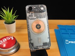 Transparante iPhone Air met interne onderdelen en koperen oplaadspoel op een houten bureau (bron: Phone Repair Guru via YouTube)