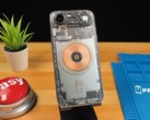 Transparante iPhone Air met interne onderdelen en koperen oplaadspoel op een houten bureau (bron: Phone Repair Guru via YouTube)