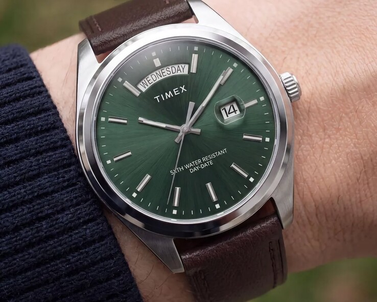 De Timex Legacy Day and Date om een pols, met een groene wijzerplaat met sunray-afwerking.