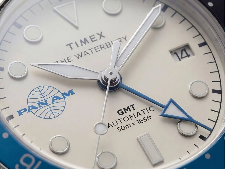 Close-up van het Timex Pan Am Waterbury Automatic GMT-horloge, met de zilverwitte wijzerplaat, lichtgevende uurmarkeringen, datumvenster en het Pan Am-logo.