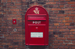 De prijs van digitale verandering: PostNord werknemers verliezen hun baan. Afgebeeld: Rode brievenbus in Denemarken (Afbeeldingsbron: Wikimedia Commons)